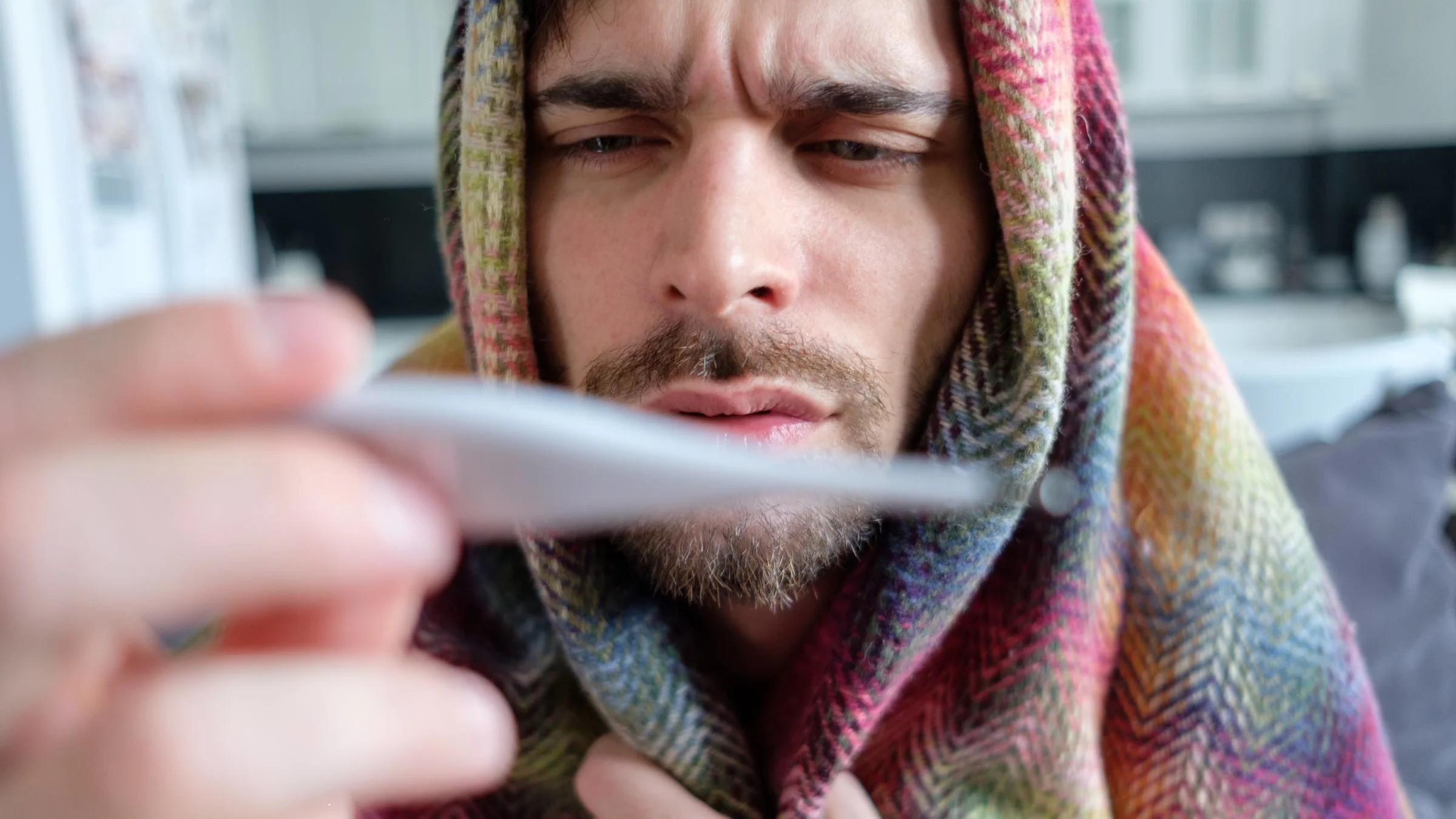 A person looking at a thermometer.