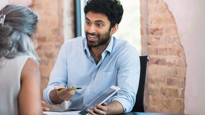 A financial advisor showing a tablet to their client. 