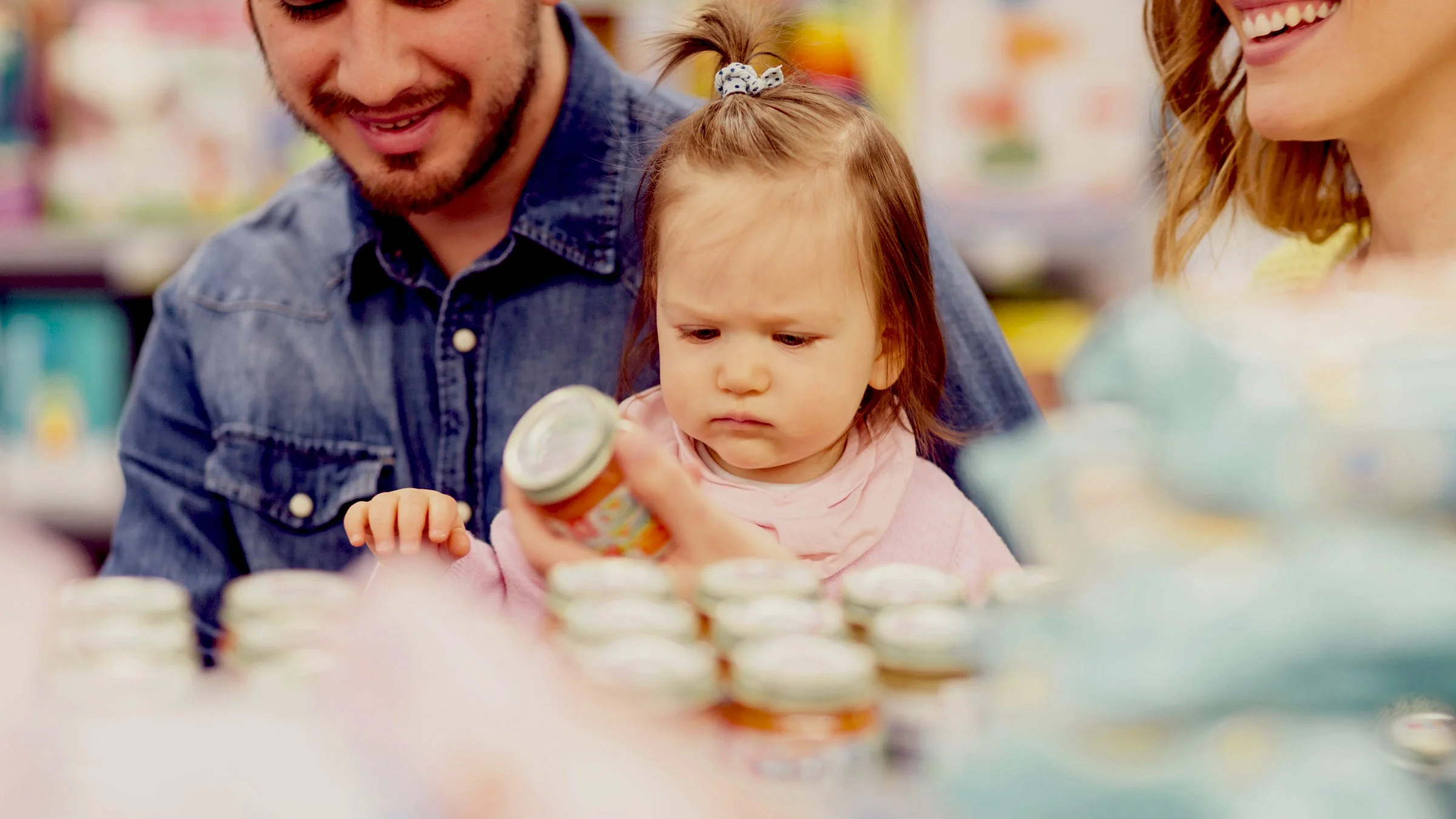 A family picking out baby food at the grocery store.