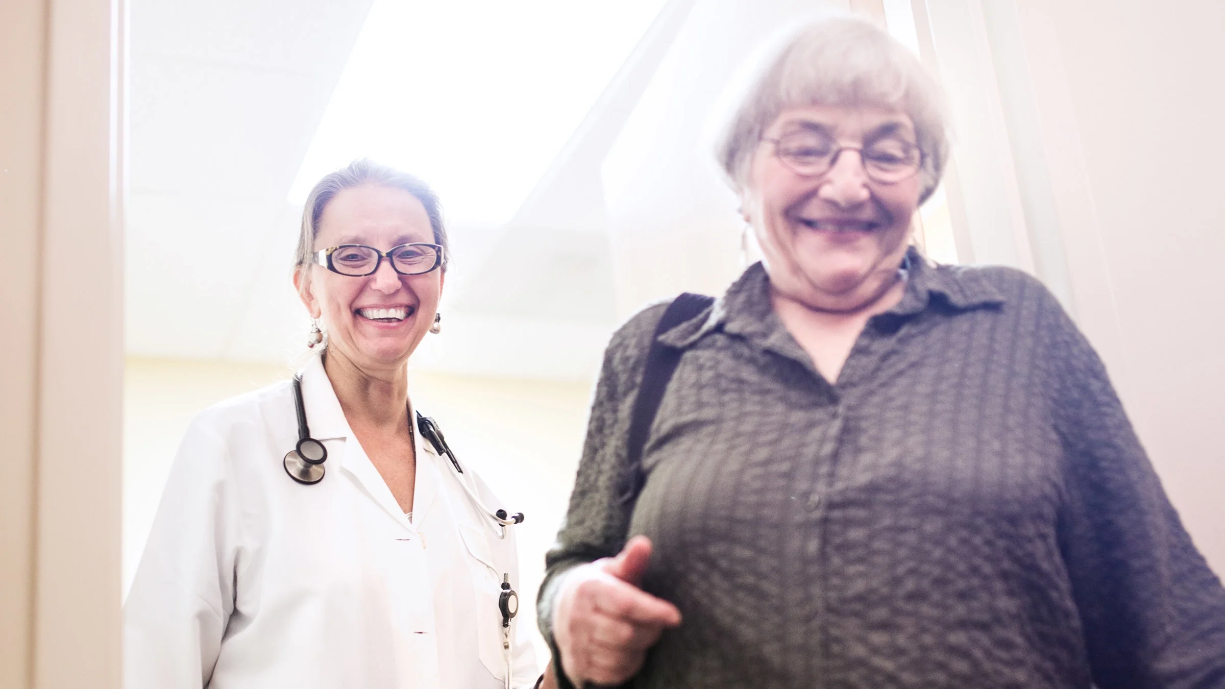 A doctor walking their patient out of the exam room, after their visit.