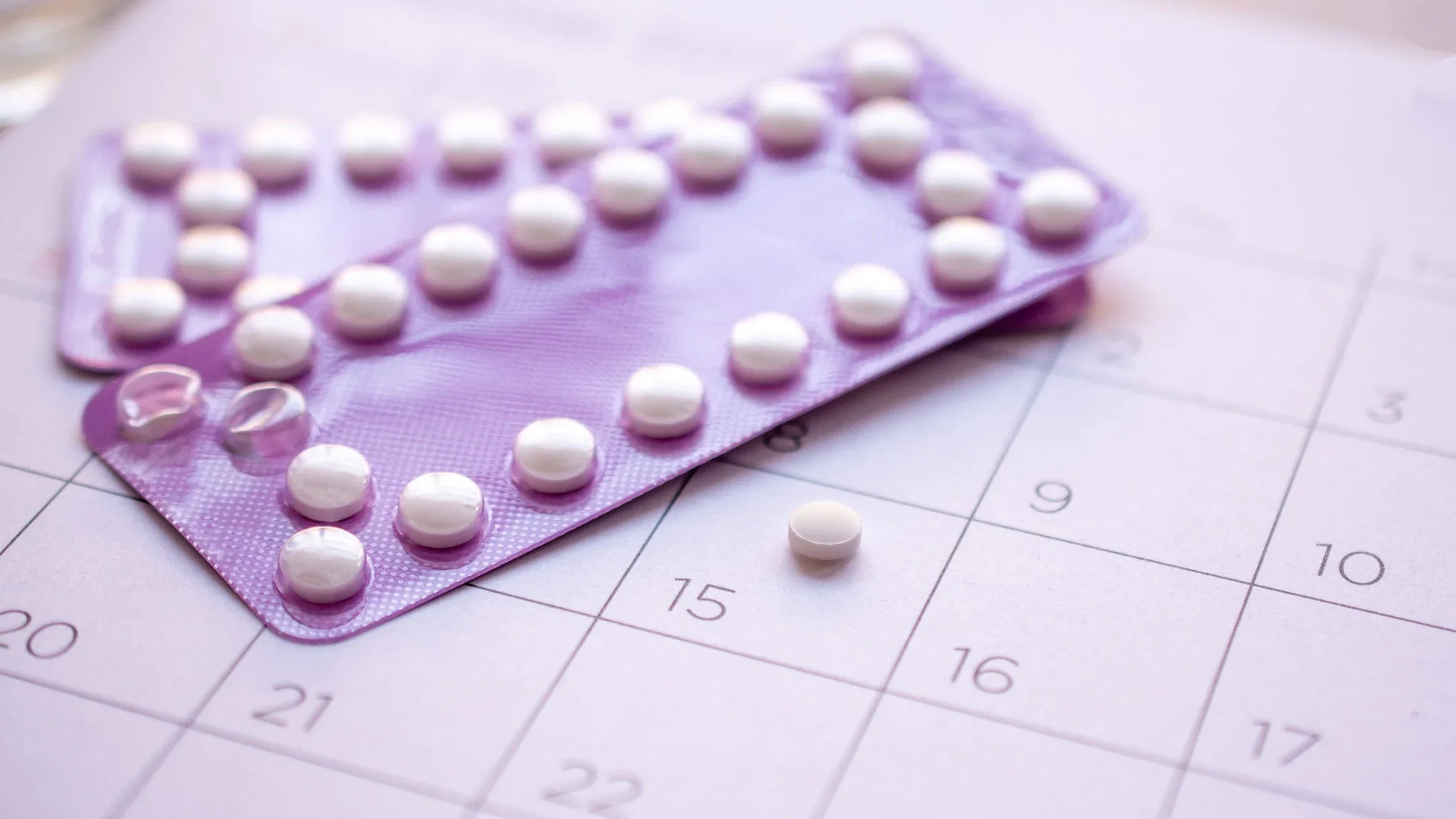 Birth control pills on top of a calendar. 
zenstock/iStock via Getty Images