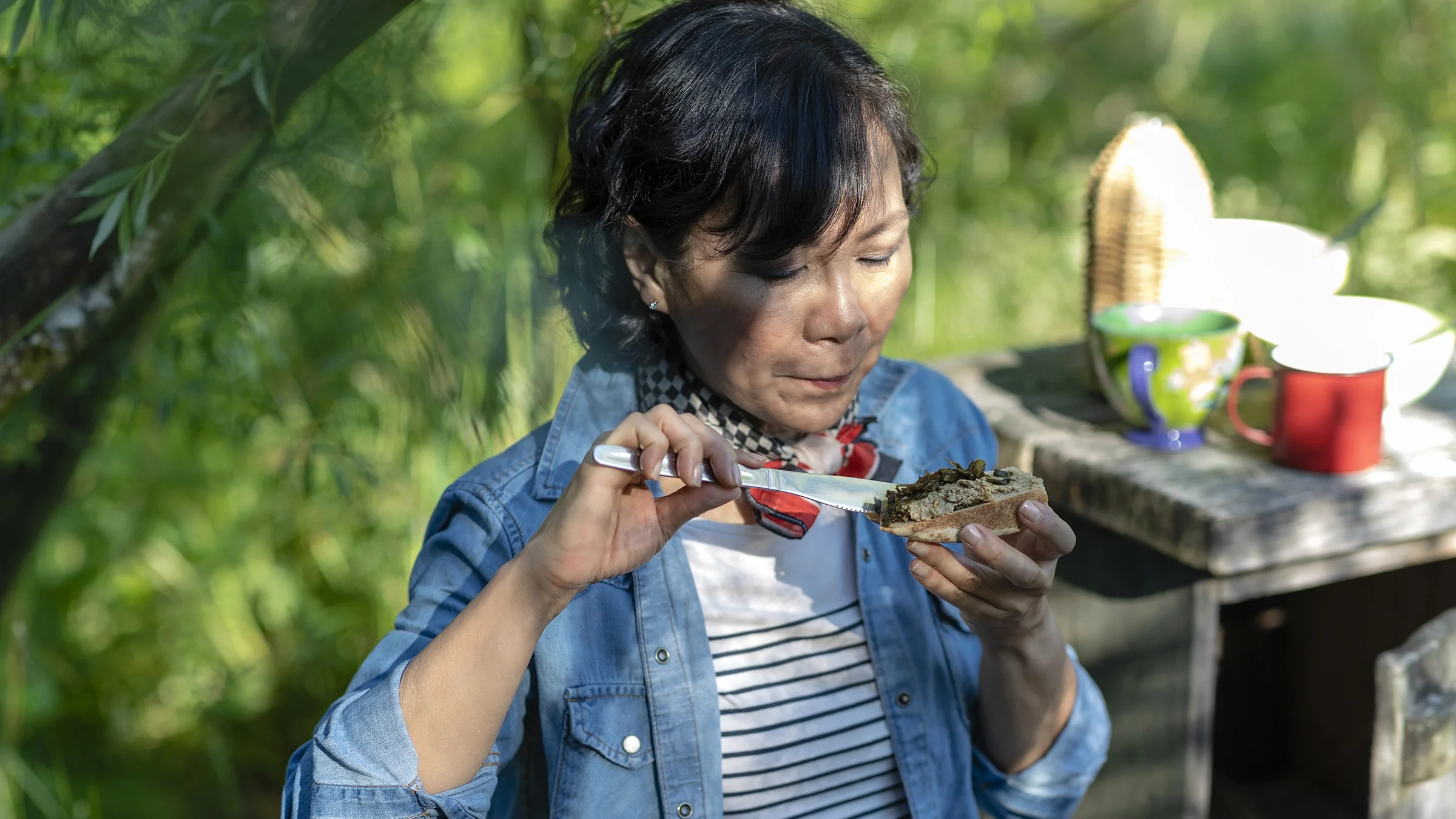 A woman is shown eating a plant-based snack while outdoors.