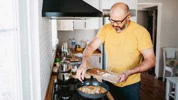 diet-nutrition: man frying eggs 2154508523