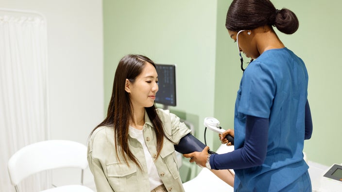 Medical professional measuring blood pressure of a patient.