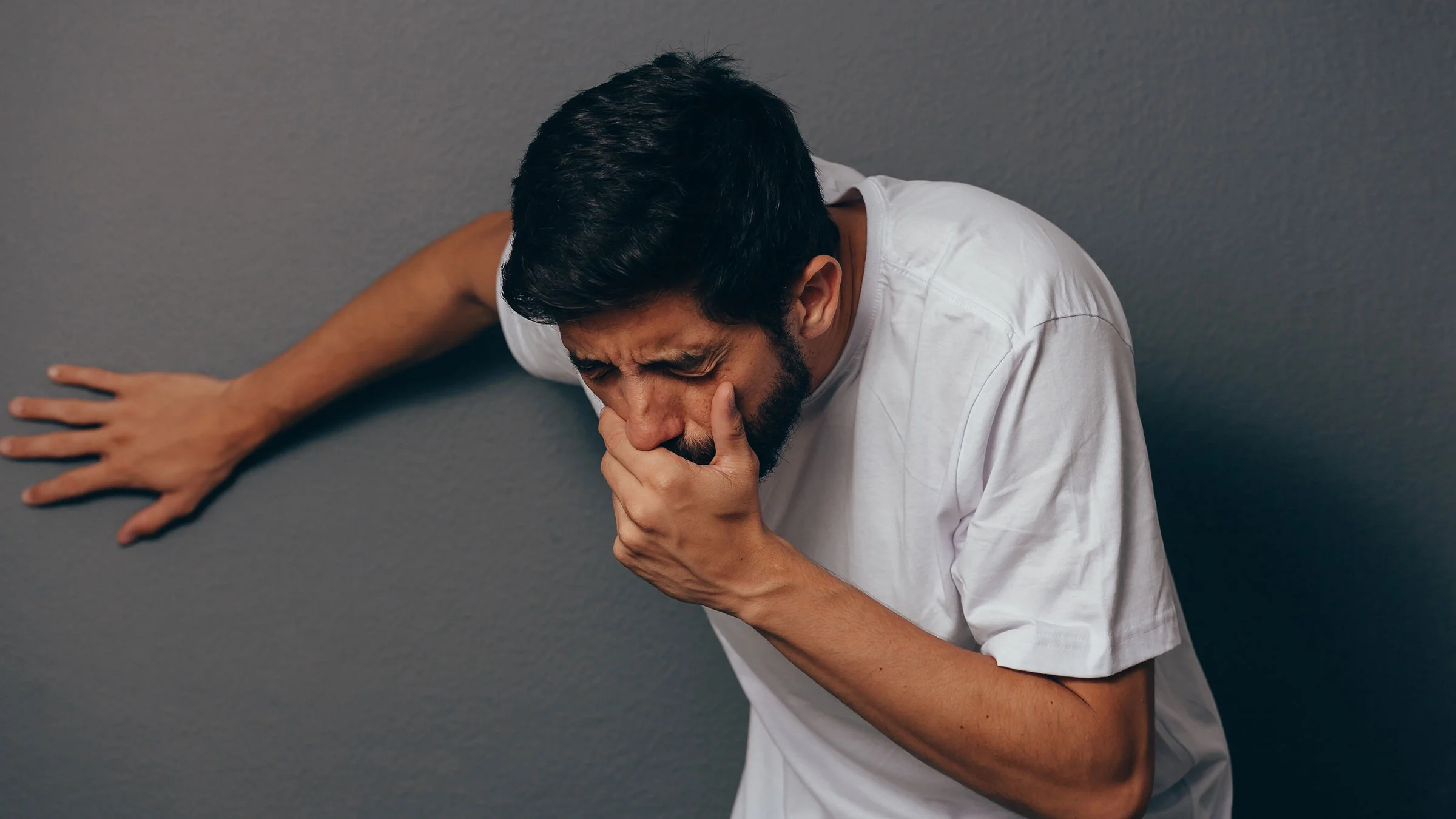 An adult is on the verge of vomiting.