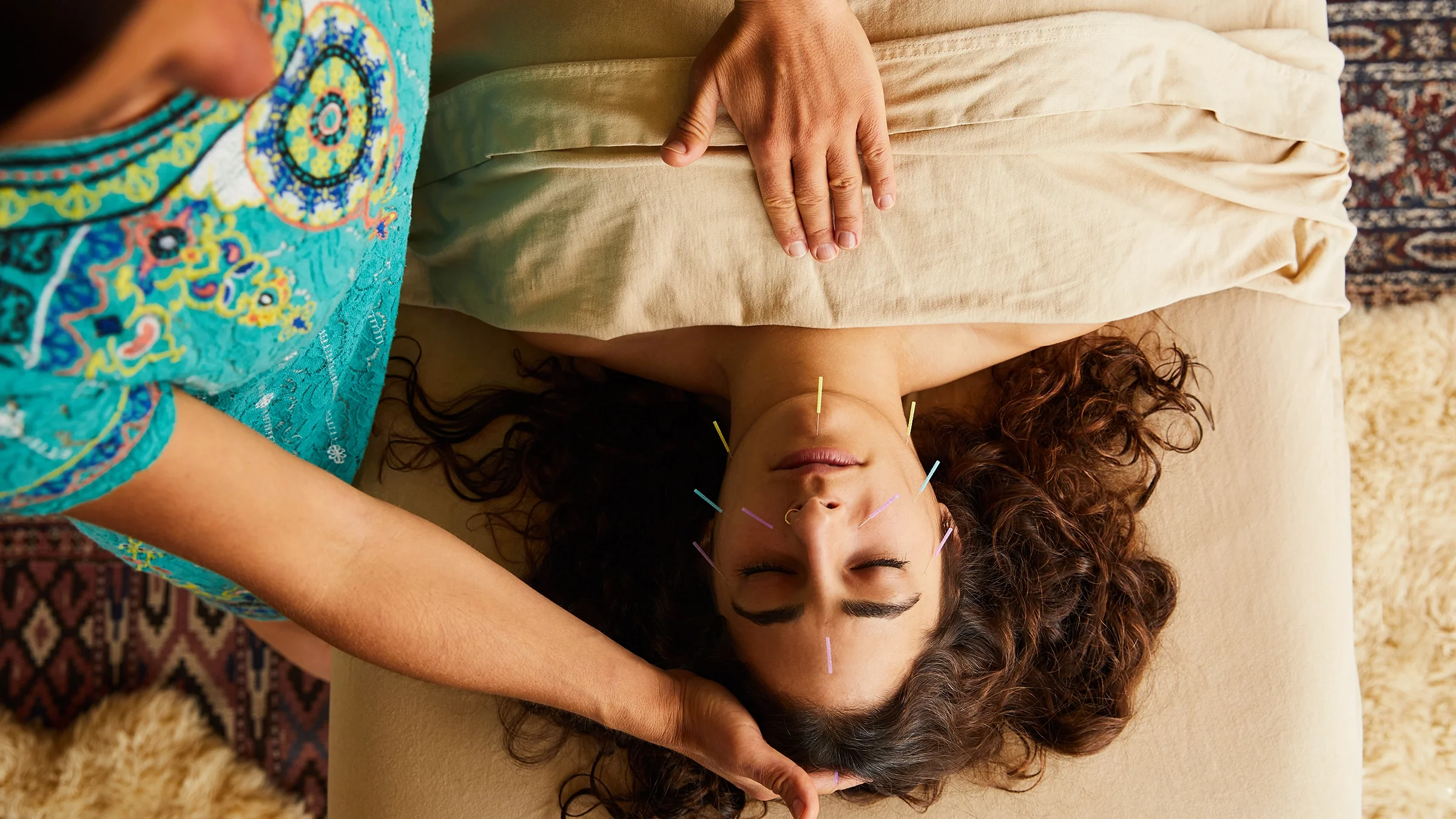 High angle of a woman having a treatment done on her face by an acupuncturist