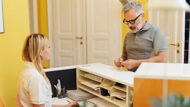 Substance use disorder: affordable treatment: handing card to receptionist 1251516629
