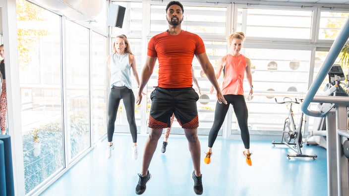 Group of people doing burpee exercise in the gym.