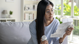 A woman reads a medication pamphlet at home.
Filmstax/E+ via Getty Images