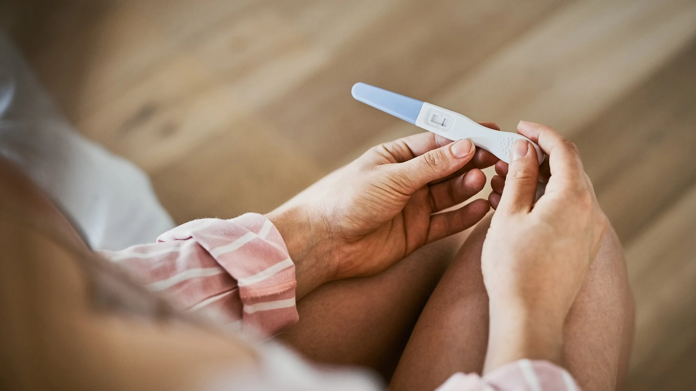 Cropped shot of a person holding a negative pregnancy test result in their hands.