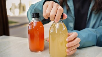Diet Nutrition: closeup opening bottle of kombucha 1905090309