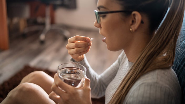 A person taking a pill.