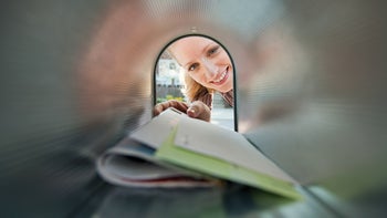 health-insurance: woman grabbing mail from mail box-107908817