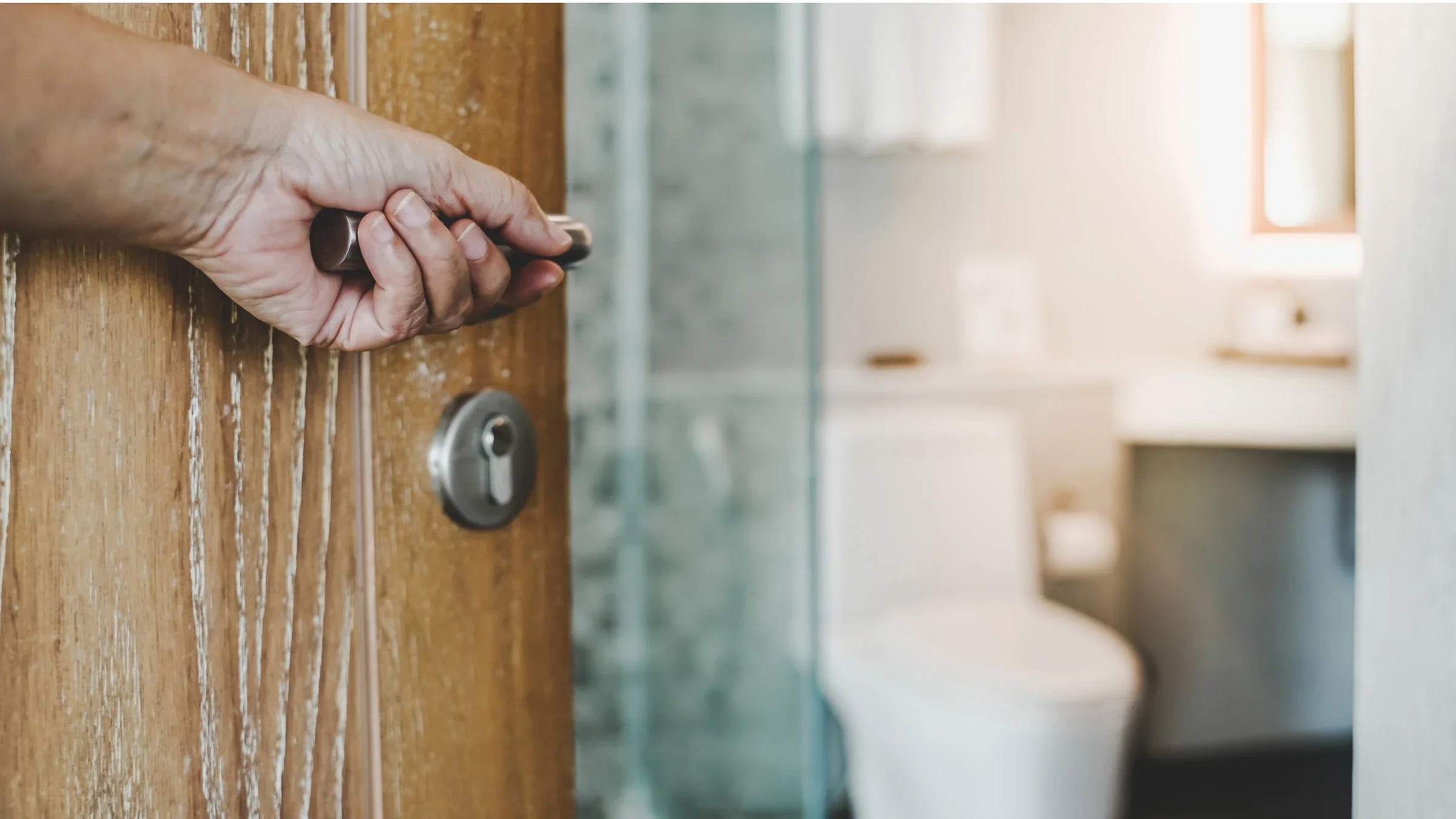 A hand opening a bathroom door. 
Ratana21/iStock via Getty Images 