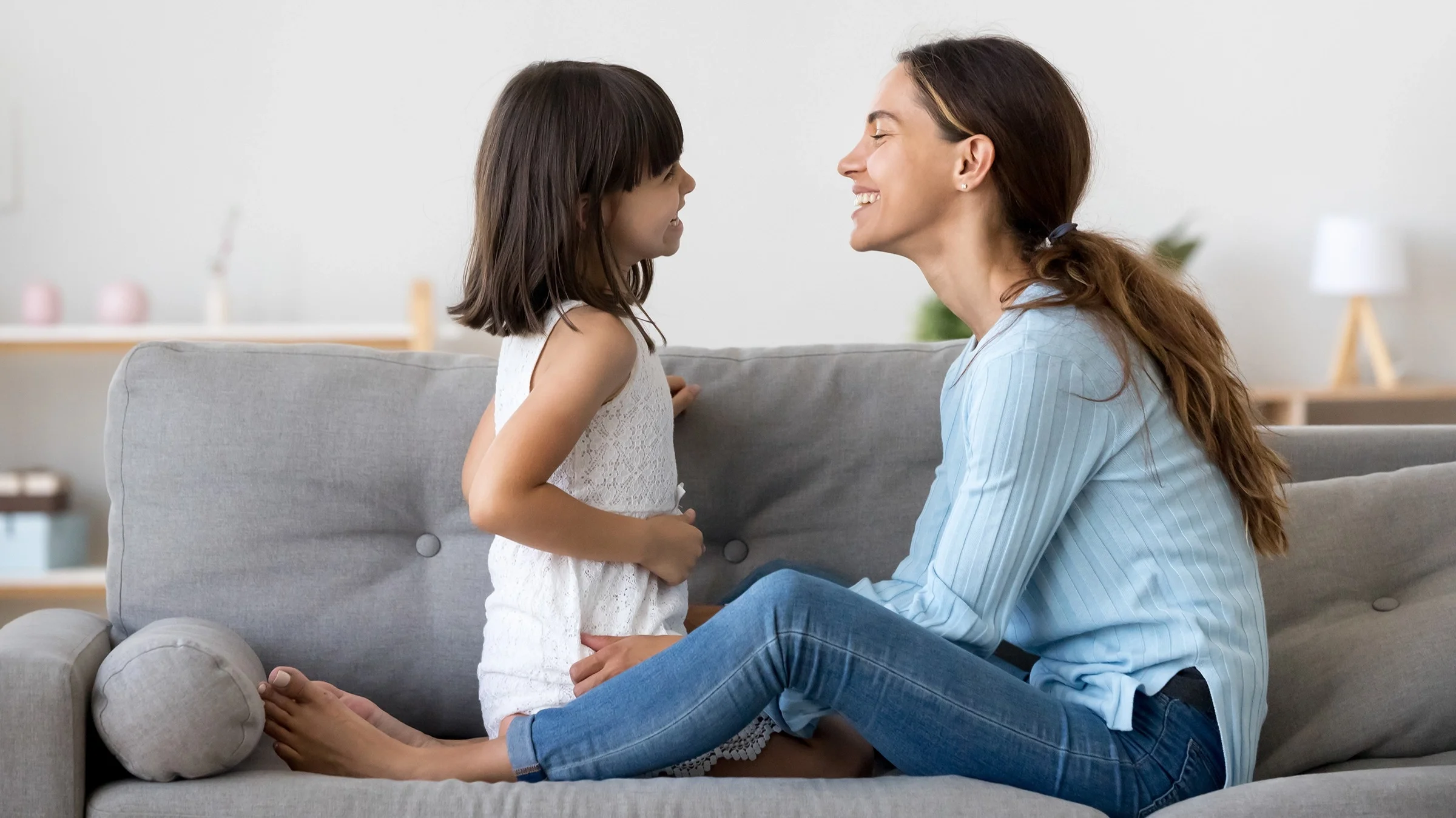 Mother and daughter spending time together playing at home in the living room.