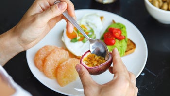 Diet and nutrition: closeup eating passion fruit with a spoon 1025302392