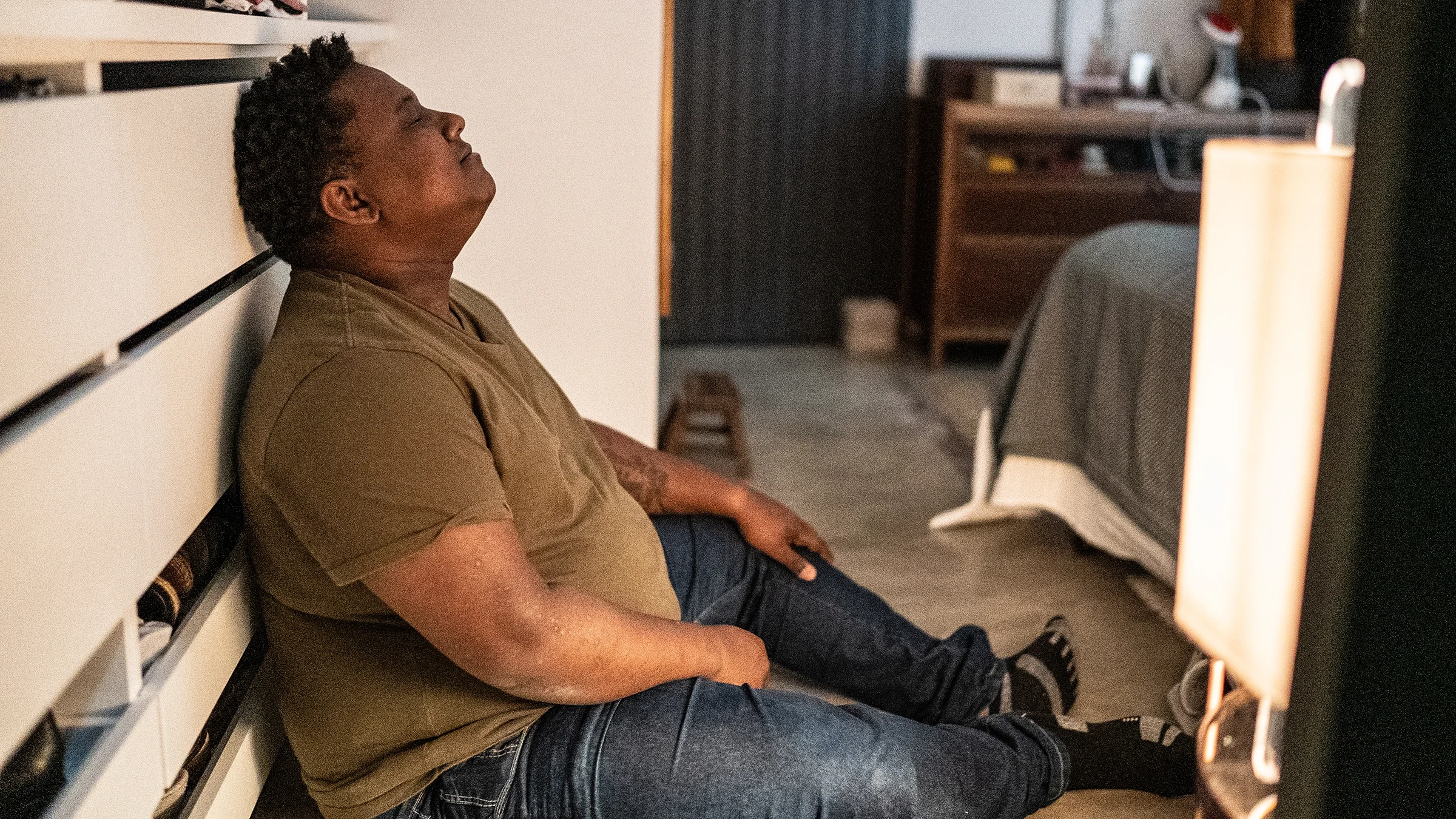 A man sits on the floor with his eyes closed. 