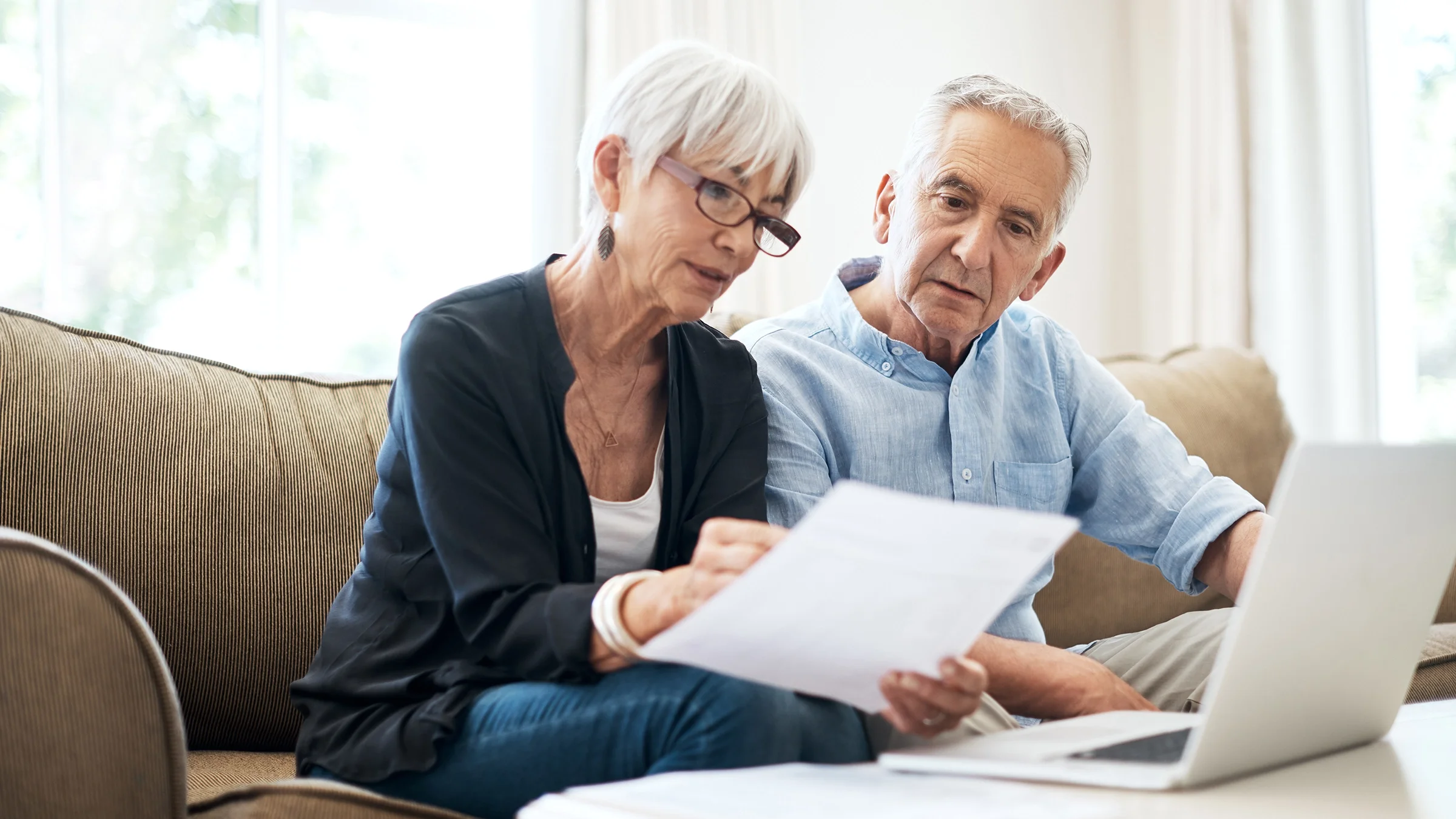 A senior couple navigates finances at home.