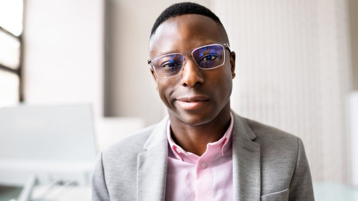Close-up portrait of a man with clear glasses.