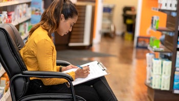 Pharmacy: woman in pharmacy filling out a form 1182903280