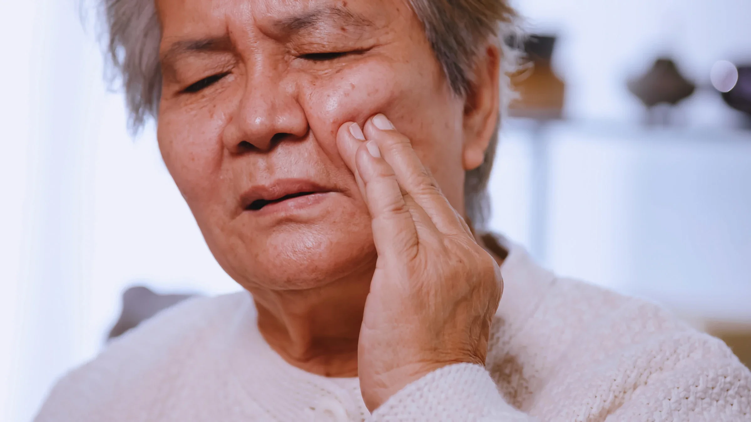 A senior adult experiencing jaw pain.
trumzz/iStock via Getty Images Plus 