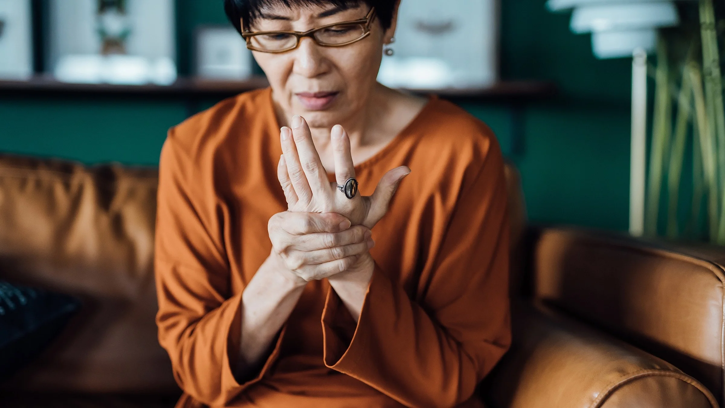 Older woman rubbing her hand and wrist from pain.