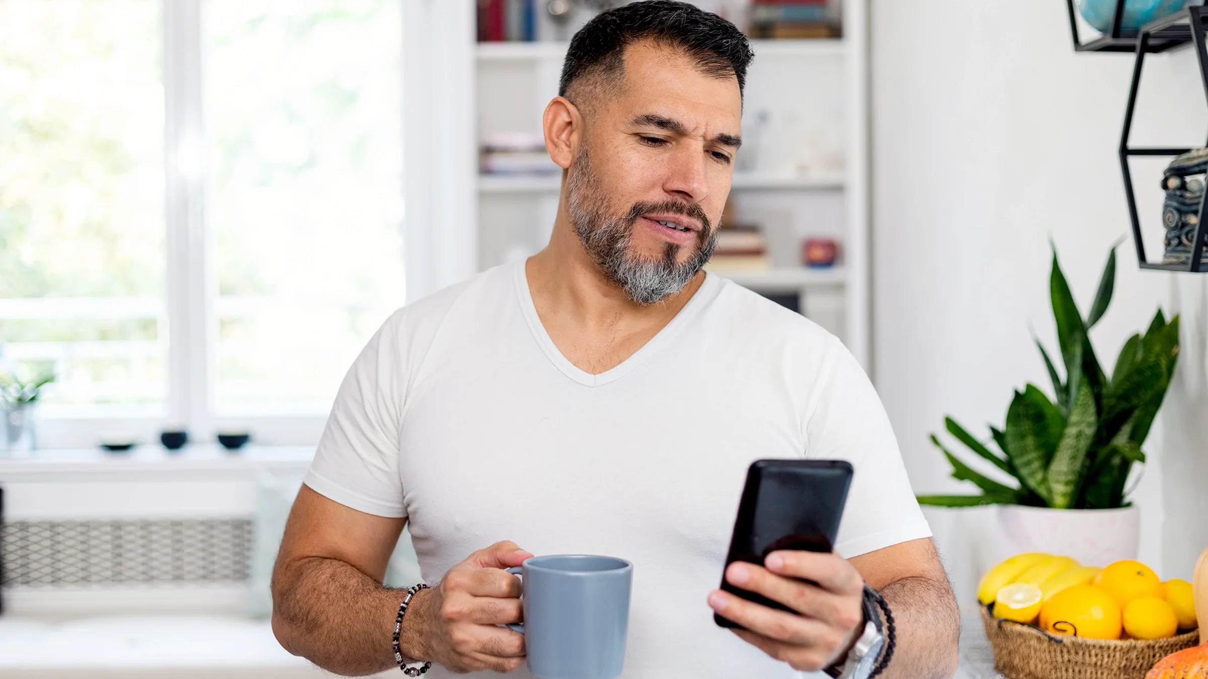 A man looks at his mobile phone at home.