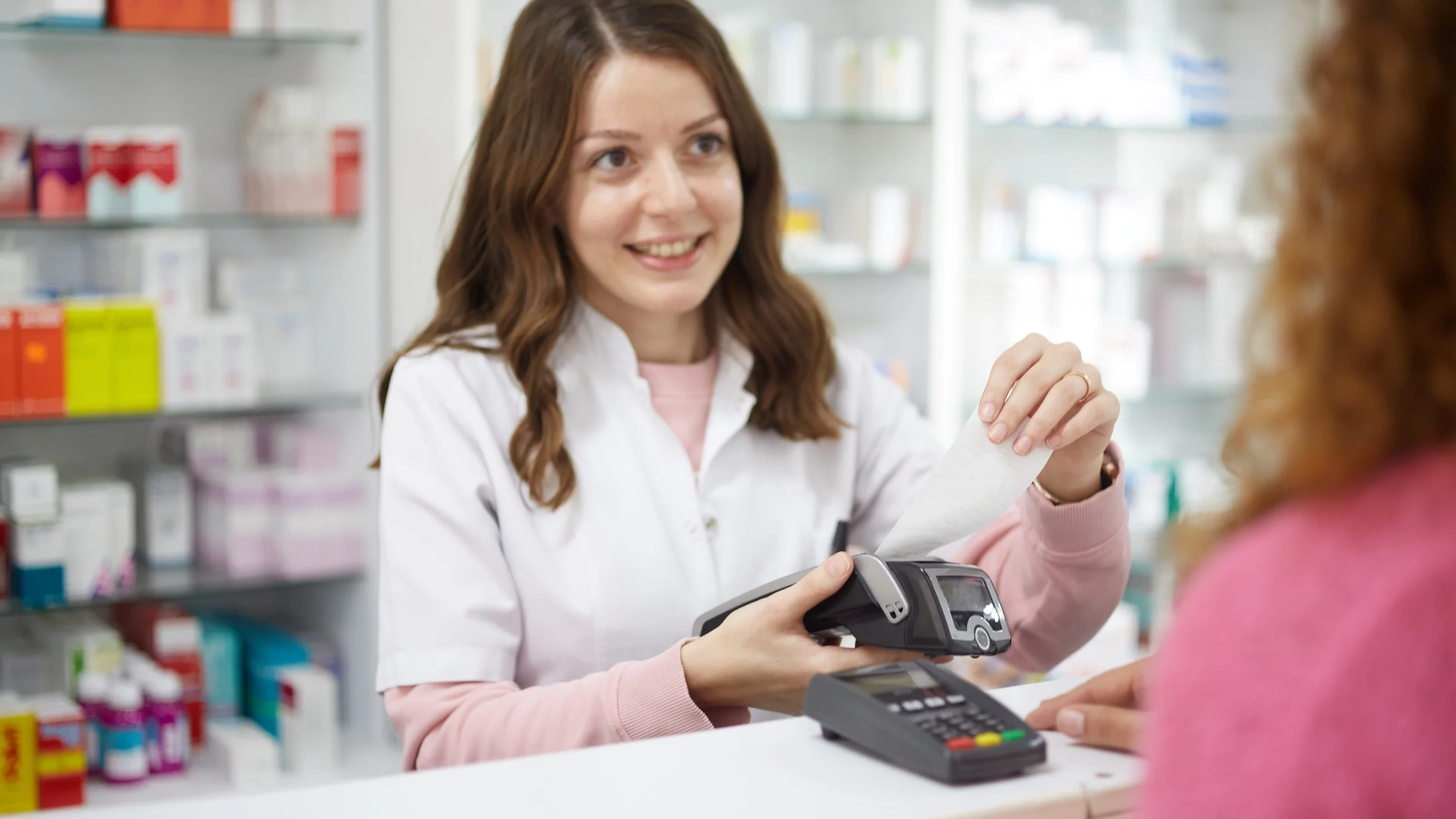 A pharmacist completing a transaction at a pharmacy.