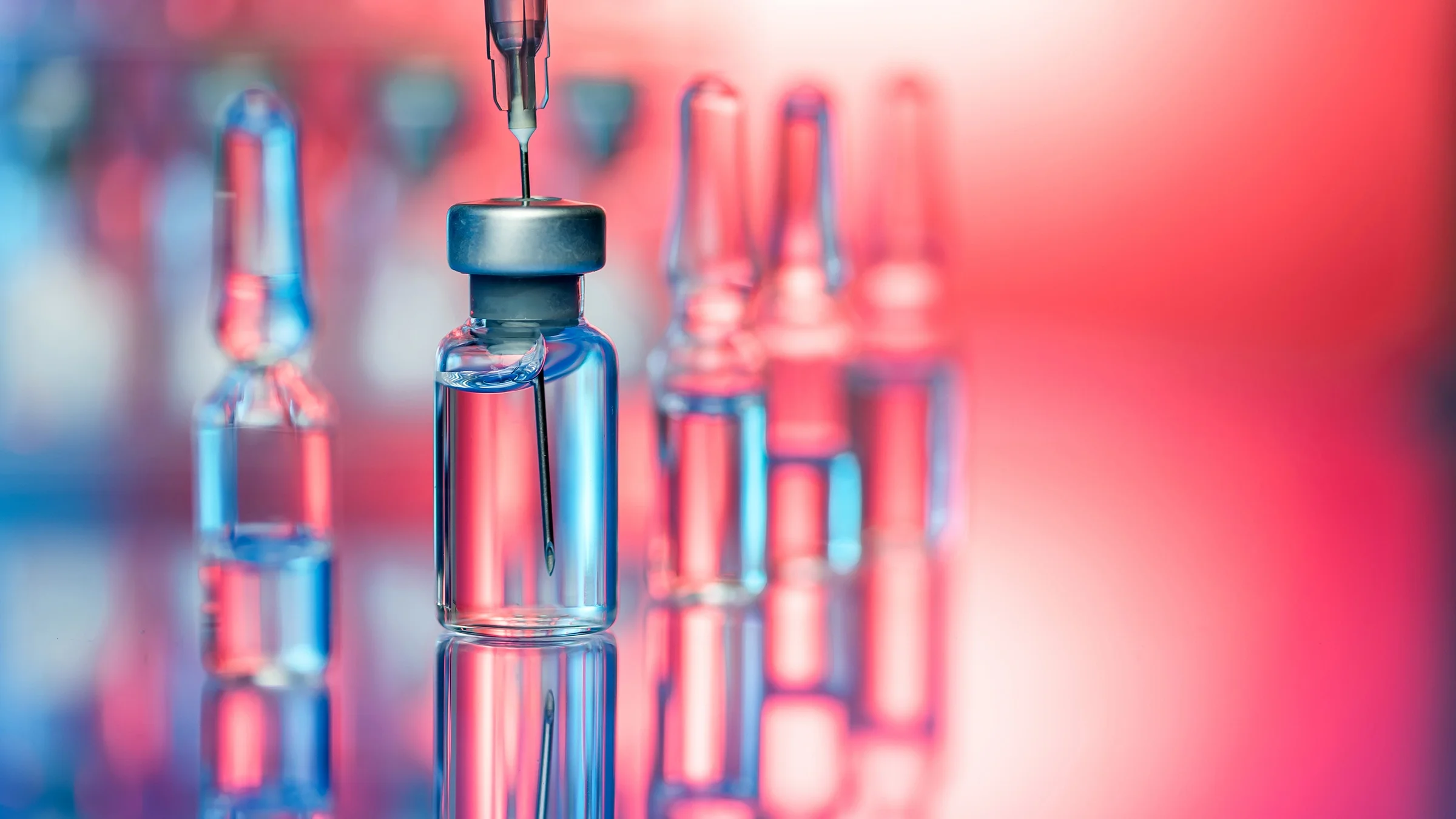 A needle has been injected into a vial of medication.