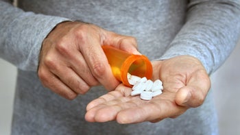 Finasteride: closeup pills man hand 666792964
