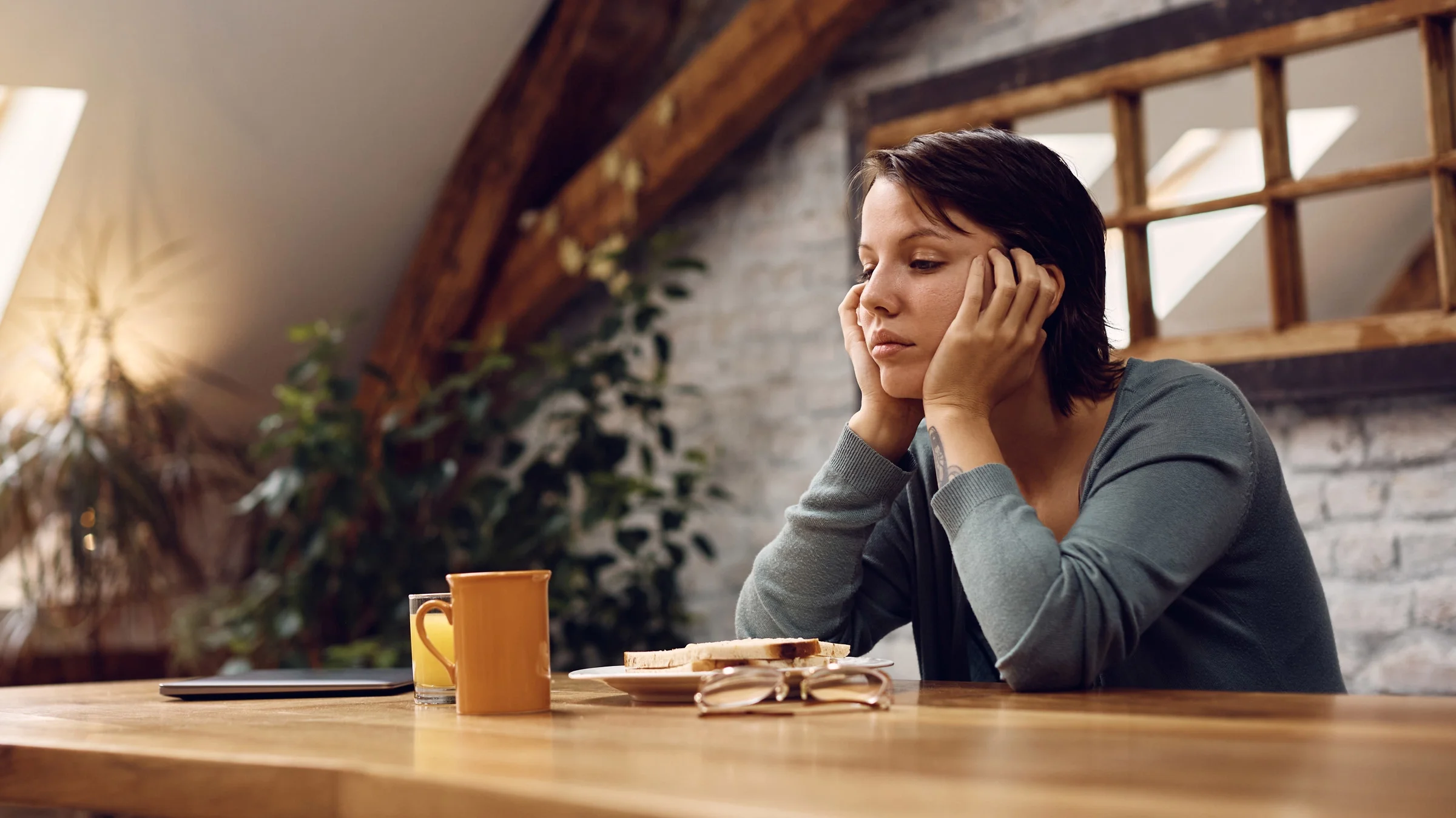 A depressed person staring at their food, due to a lack of appetite.