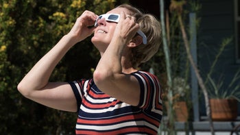 Eye pain: Solar retinopathy: woman looking up solar eclipse glasses-836809610