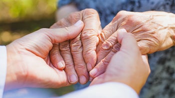 Health: essential tremor: nurse holding seniors hands-846436068
