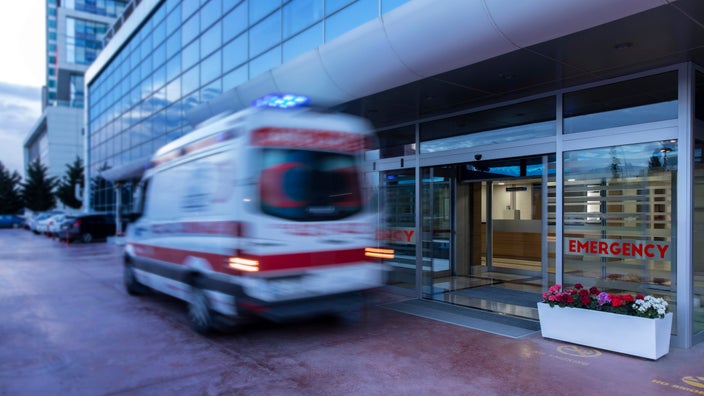 A blurry ambulance outside an emergency room entrance.