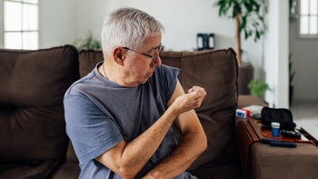 Diabetes: man giving himself insulin injection in arm 1606163363