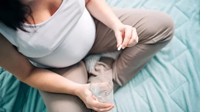 Health: parenthood-pregnancy: top view pregnant woman taking supplement 1292322622