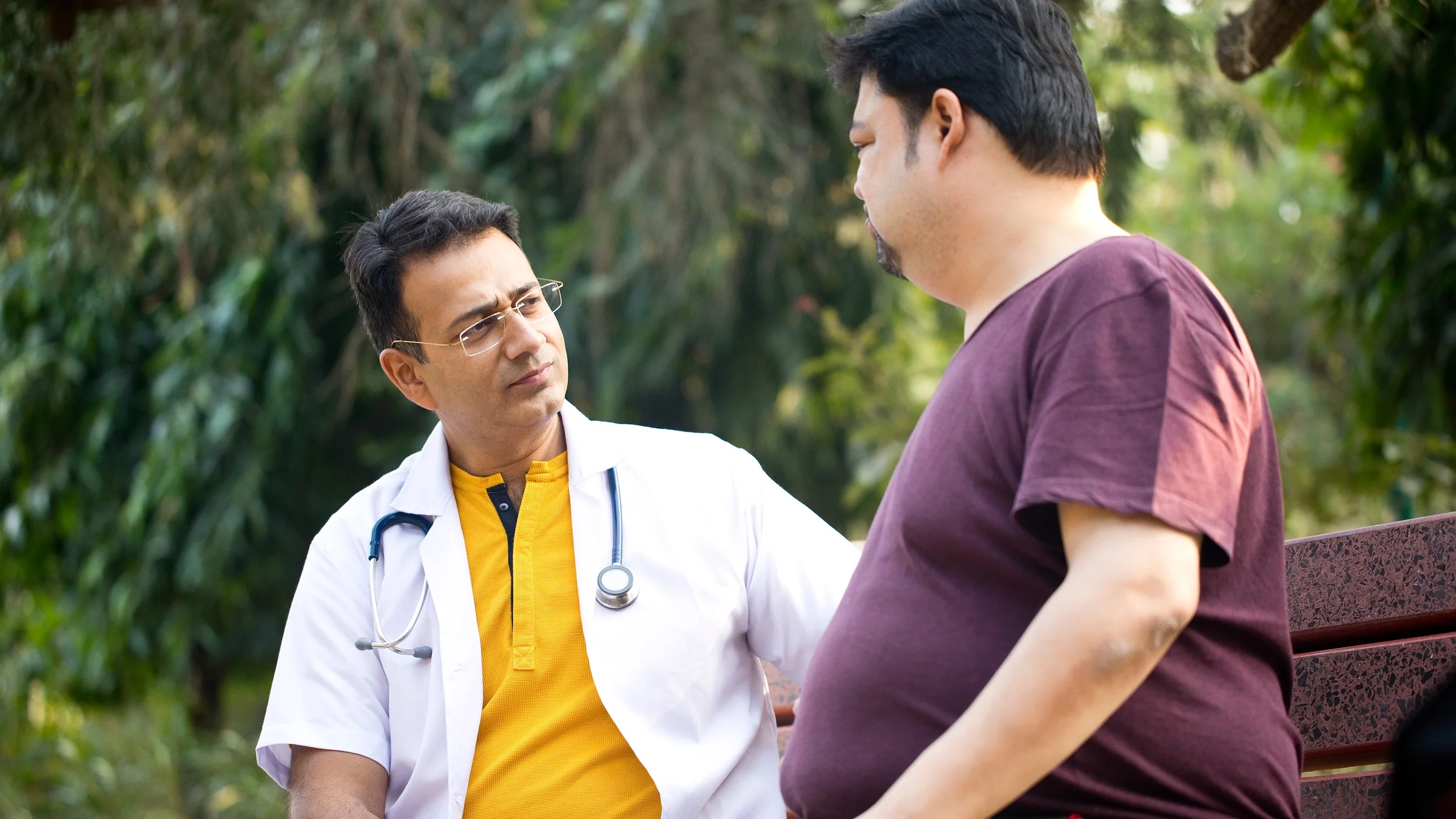 A patient talking to their HCP on a bench.