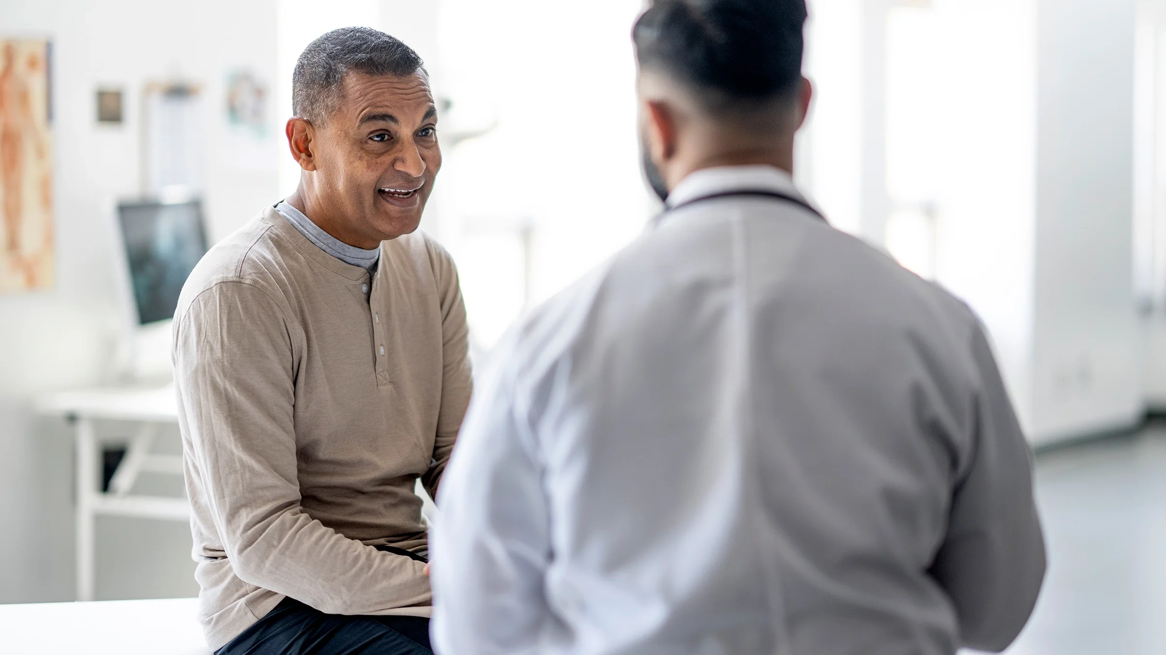 A man speaks with a healthcare professional at a medical appointment.