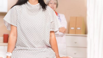 wearing-hospital-gown-on-surgical-table-845603112