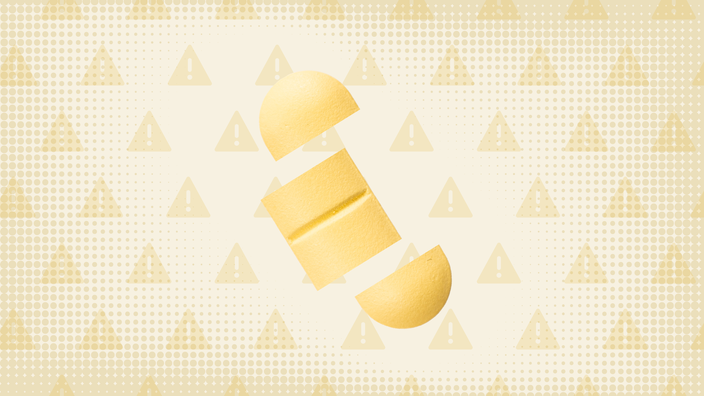 In the center of a light yellow-orange background with texture and warning sign pattern is a yellow oblong pill cut into thirds. 