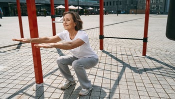movement exercise: woman doing squat exercise outdoors 1330269089
