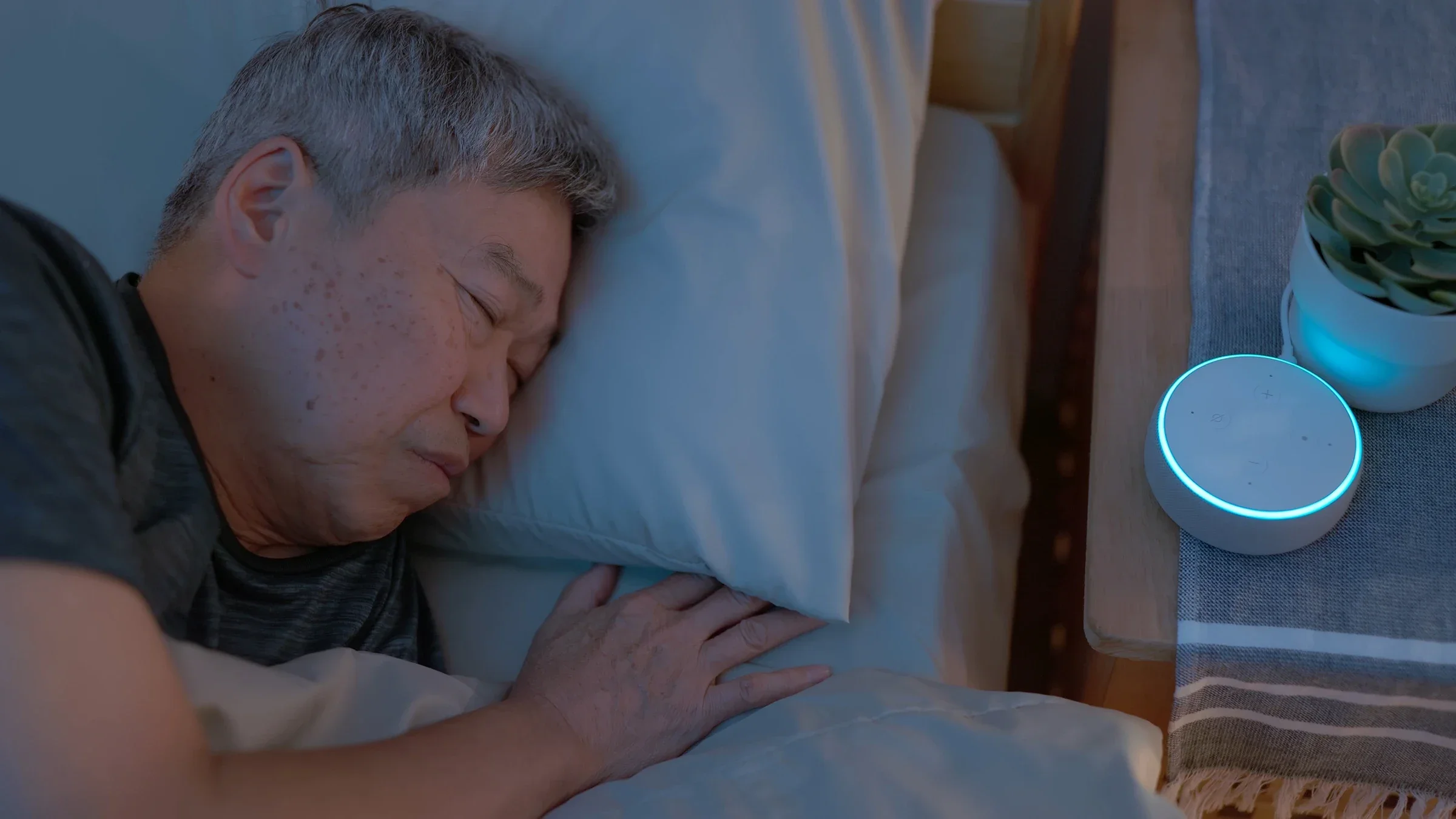 Man sleeping next to a white noise machine.
PonyWang/E+ via Getty Images