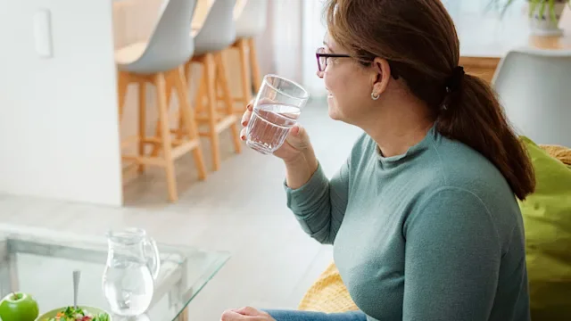 orlistat: woman drinking glass of water 2047992356