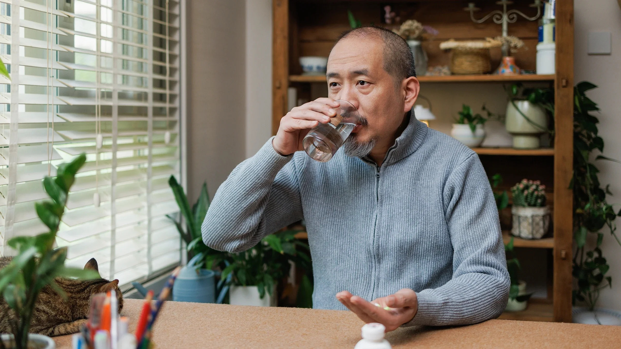 A man takes medication at home.