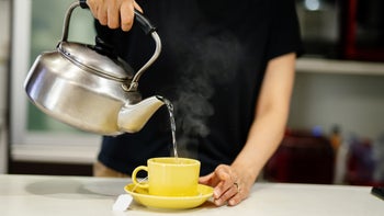 Menstrual-pain: closeup woman pouring hot water from kettle 1277769986