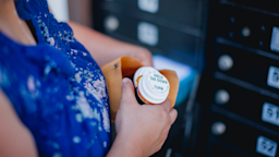 A woman opens her mail-order prescriptions. 
timnewman/iStock via Getty Images
