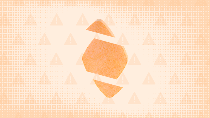 In the center of an orange background with texture and warning sign pattern is a diamond-shaped orange pill cut into thirds. 