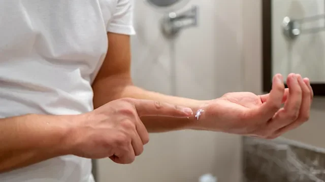 dermatology: closeup man applying cream to arm 1465476543