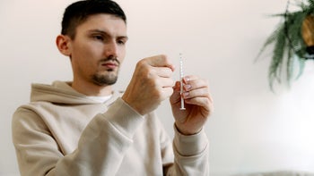 Epidiolex: man drawing medicine in syringe 2148770559