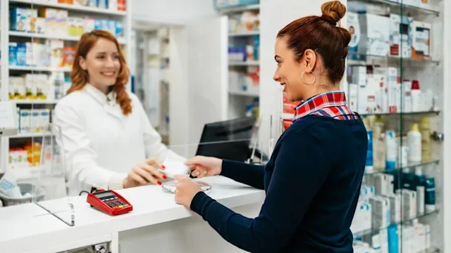 Health: Insurance: 	handing card to pharmacist 1393184187